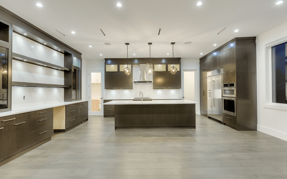 Spacious kitchen in a custom home featuring a large island and modern fixtures.